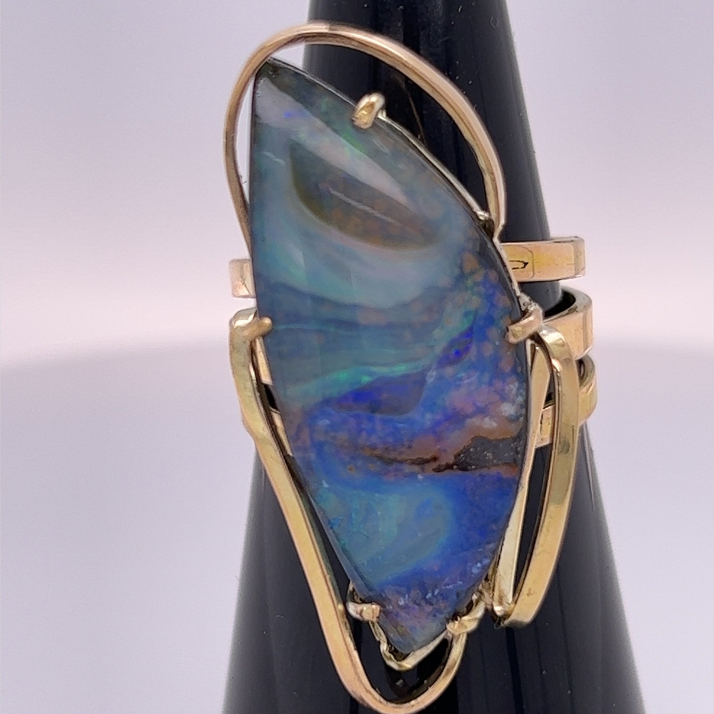 A beautiful statement ring custom made with rare Queensland Boulder opal. The stone has a perfect polish and is set in a wonderful 14ct gold triple ring.