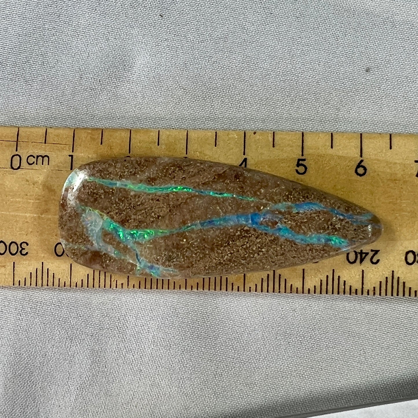 Lovely stone with aqua coloured lines throughout. Would make a statement piece pendant.