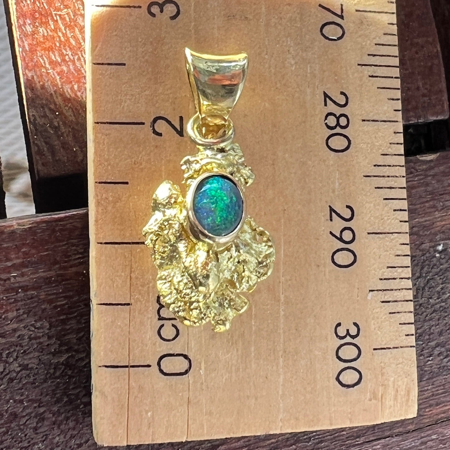 Pure gold nugget pendant from Western Australia. Perfectly set and balanced with an 18ct bale. Set with a perfectly cut solid black opal from Lightning Ridge.