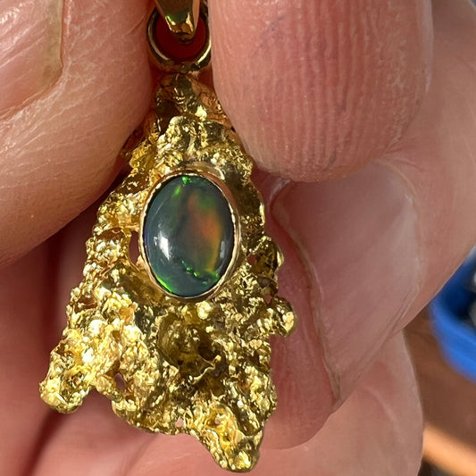 Pure solid gold nugget pendant from Western Australia. Perfectly set and balanced with an 18ct bale. Set with a beautifully cut black opal from Lightning Ridge.