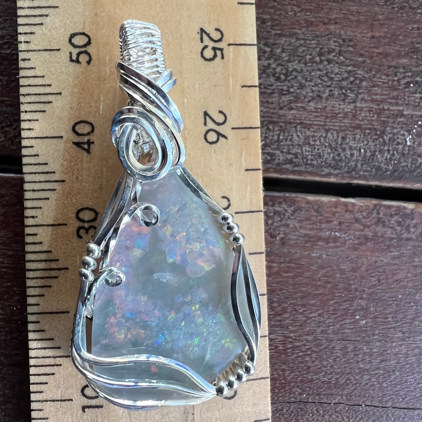 Unique Coober Pedy grey base opal on a silver hand made wire pendant. Nice colours.