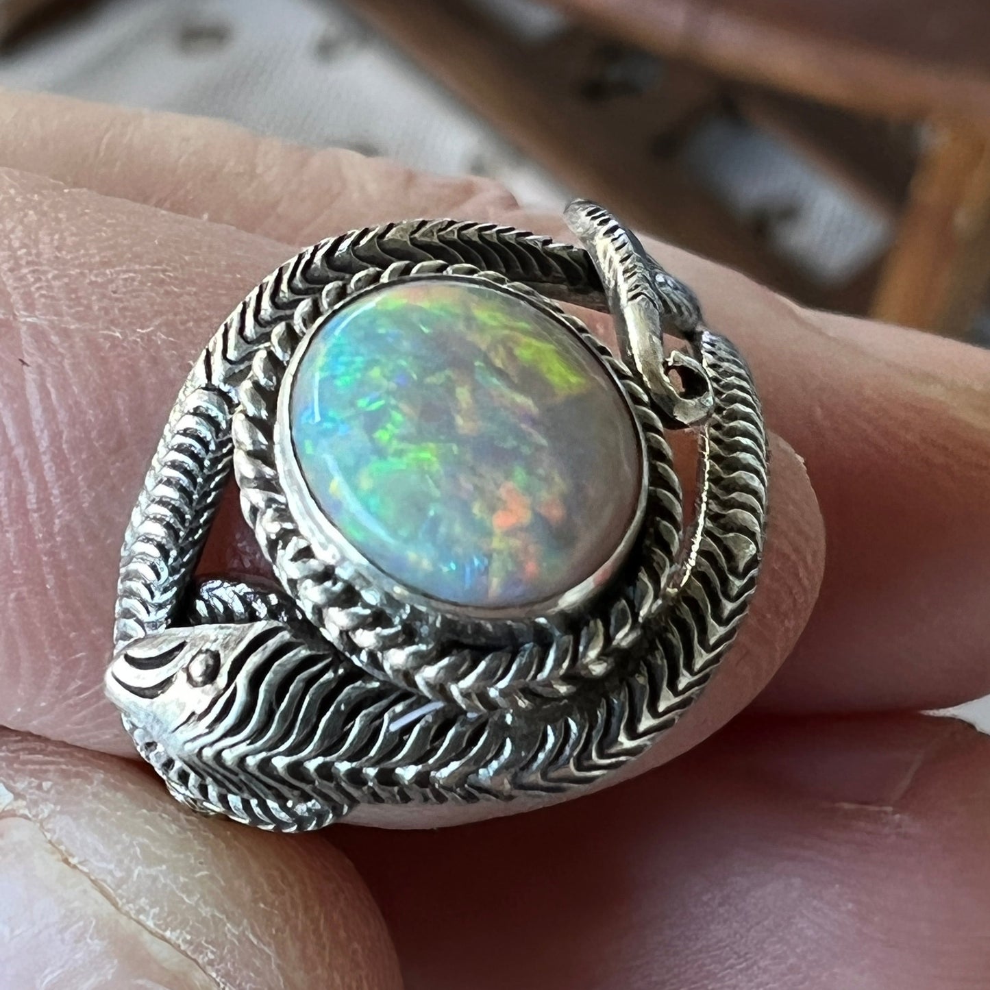 Beautifully handcrafted snake skin ring with a fantastic round cut Coober Pedy opal showing flashes of all colours.