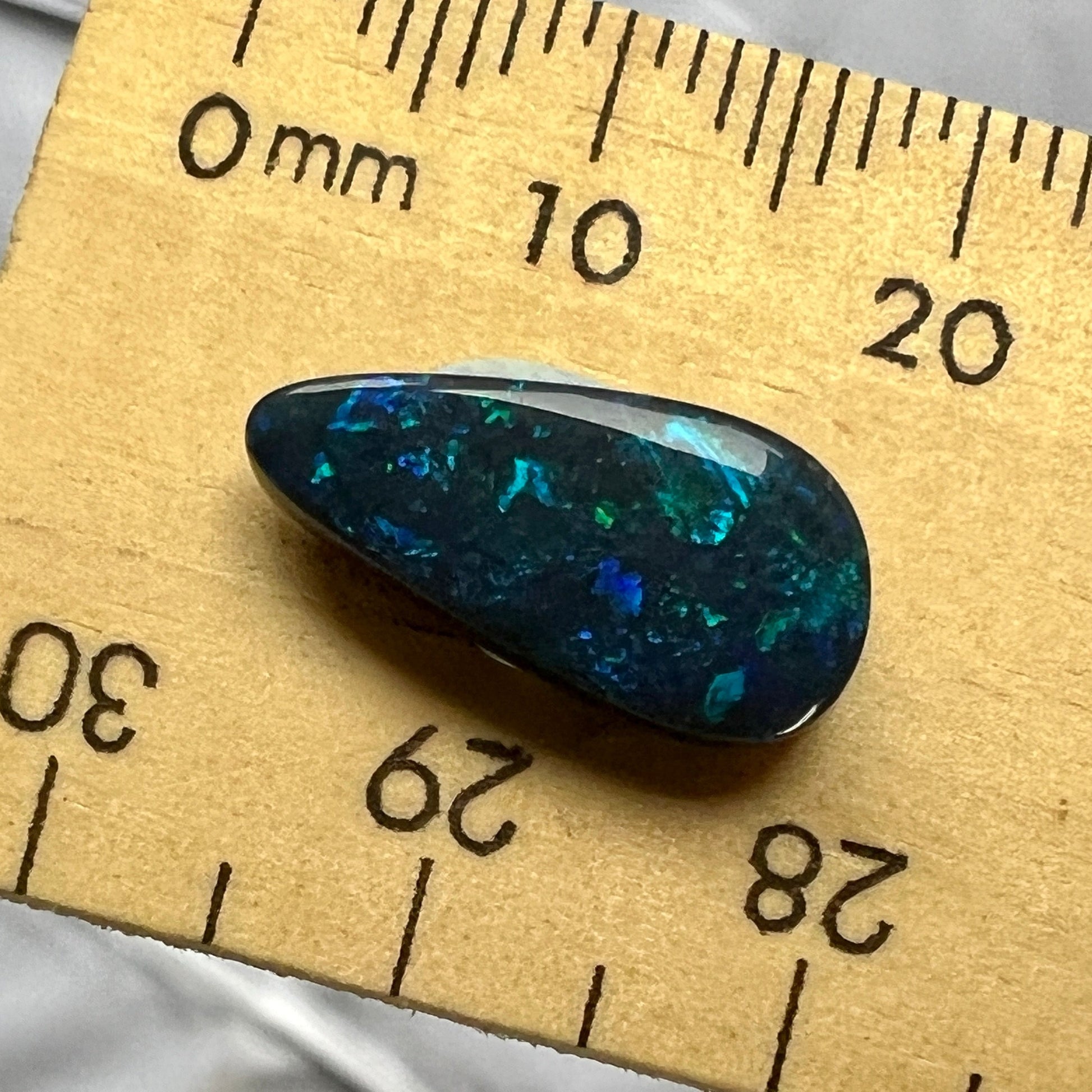 Beautiful solid black gemstone from Lightning Ridge displaying stunning blues and greens.