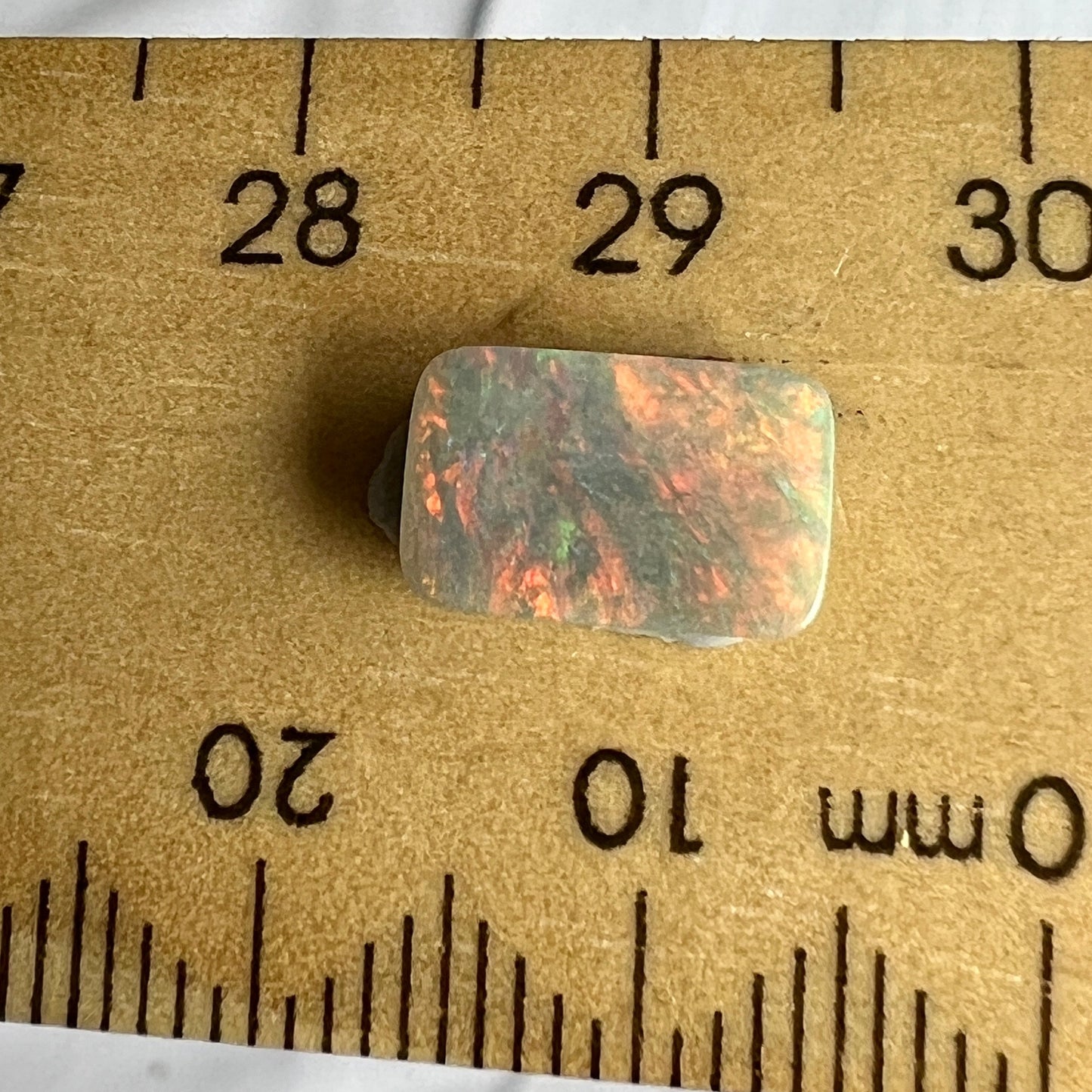 Semi-black opal from Lightning Ridge. A square cut beauty. Great pattern that shows off plenty of reds.