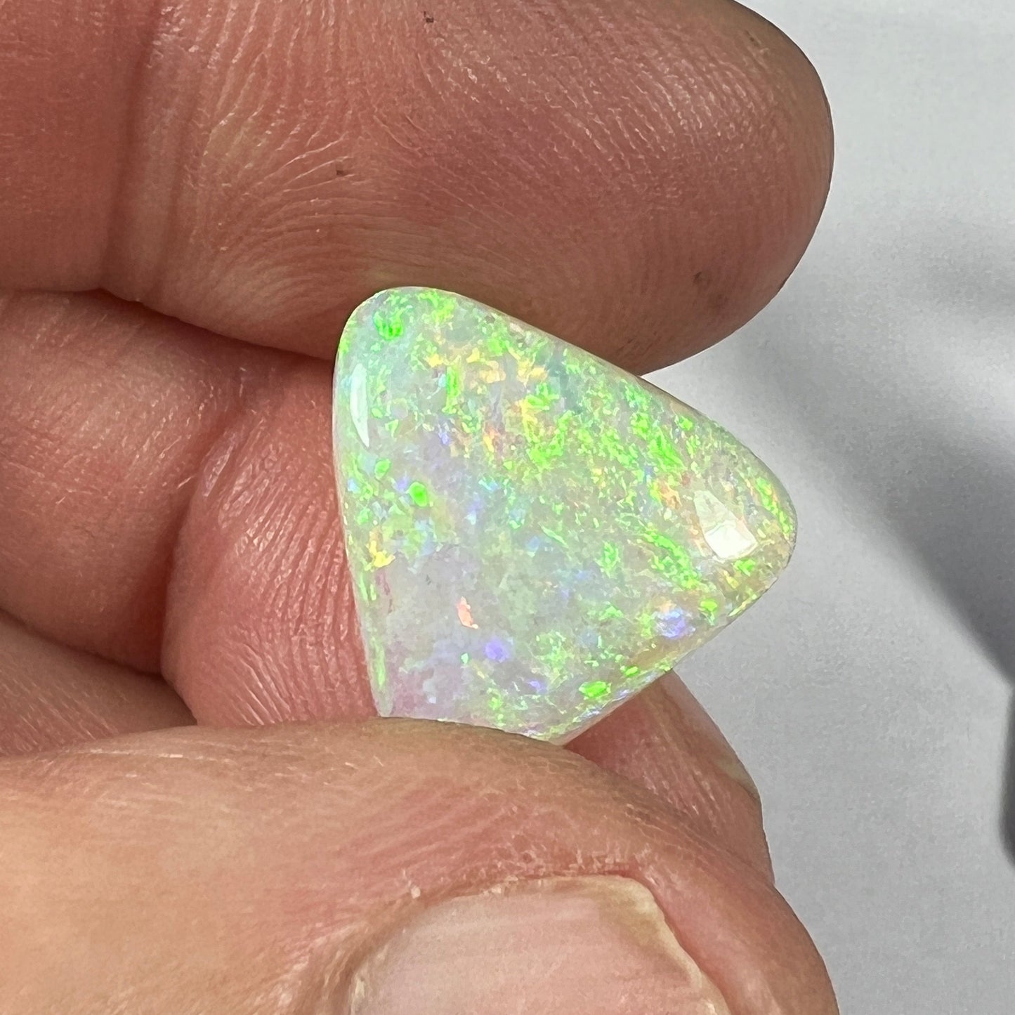 Stunning triangle shaped solid crystal opal from Grawin, Lightning Ridge.. A great shape and a spectrum of colours throughout including greens, blues and reds.