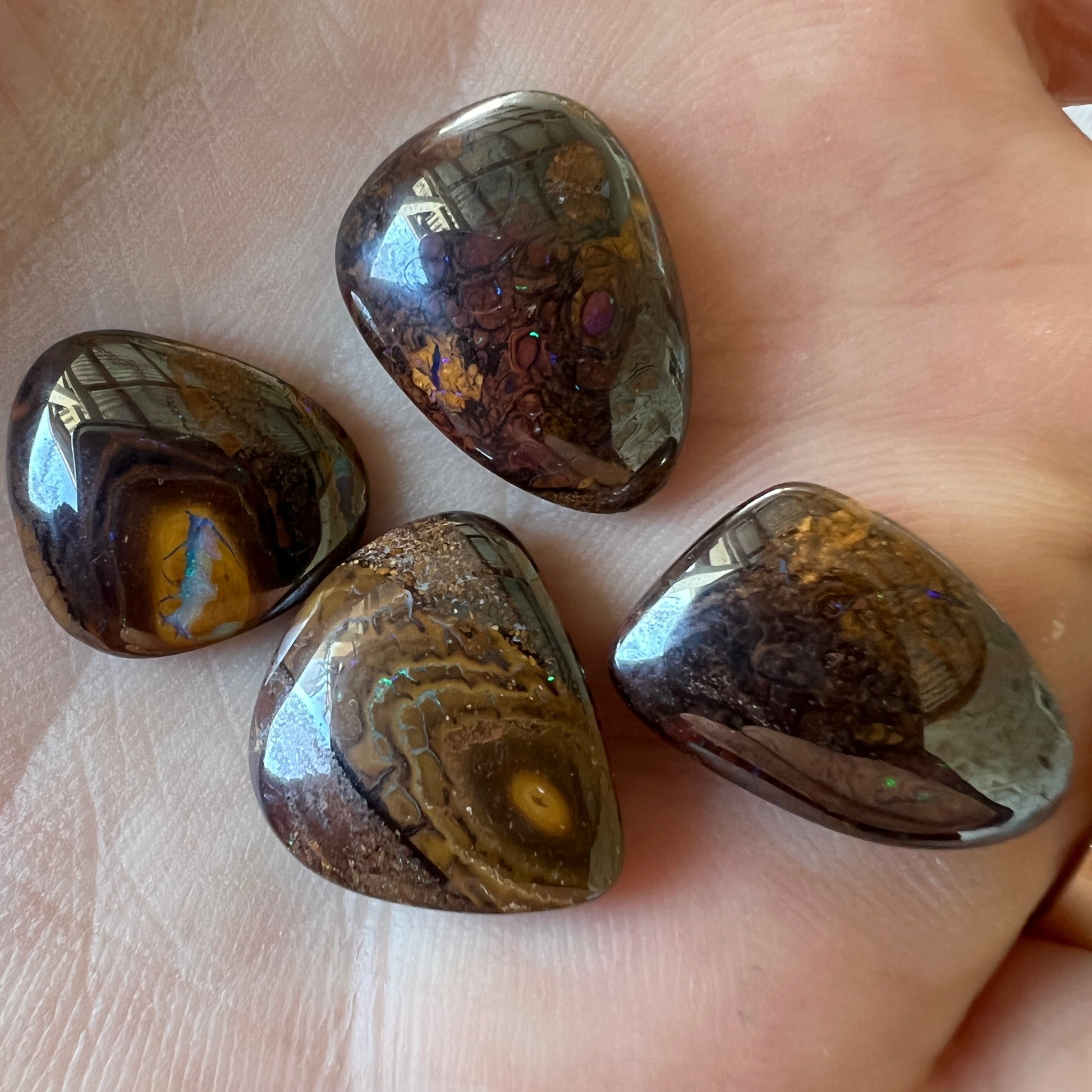 Four lovely pieces of boulder opal from Winton. Nice dome and polish showing great colours.