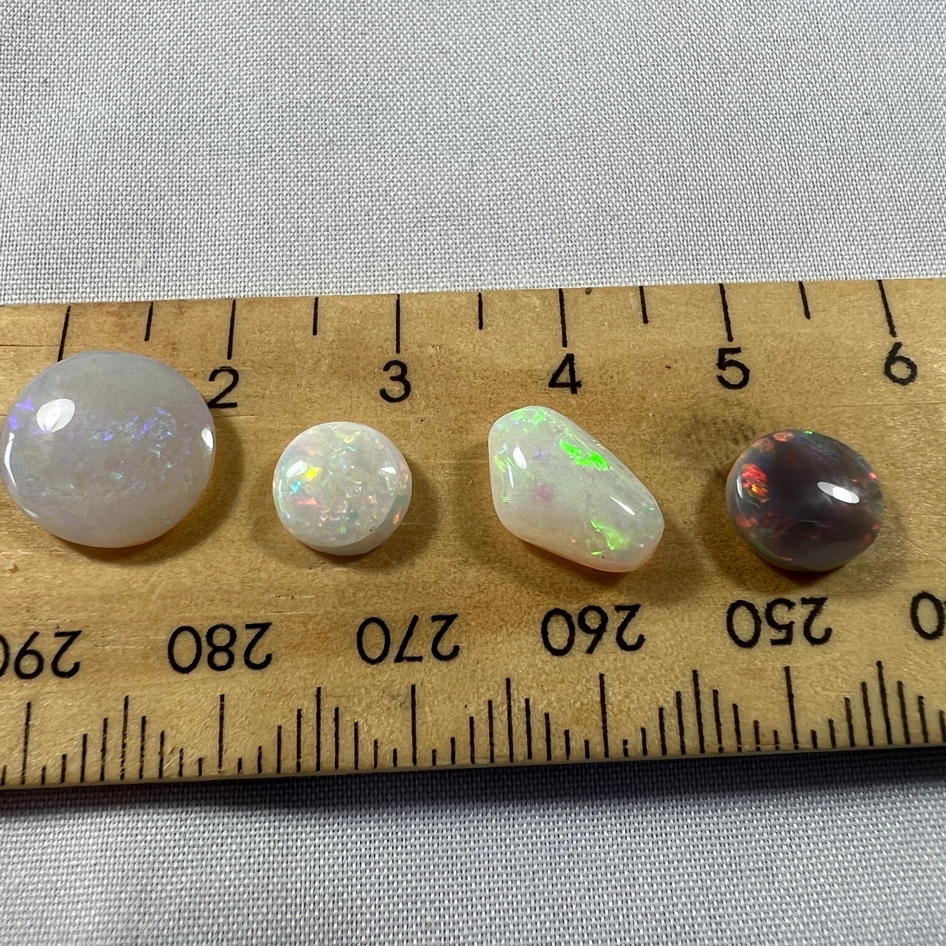 Small mixed group of four lovely solid opals that will make great ring stones. Cut and polished by Bill Johnson.