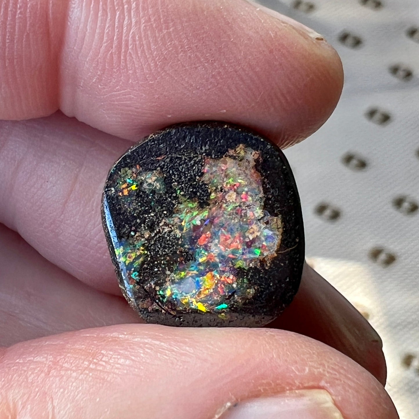 Nice round boulder opal displaying a multitude of colours.