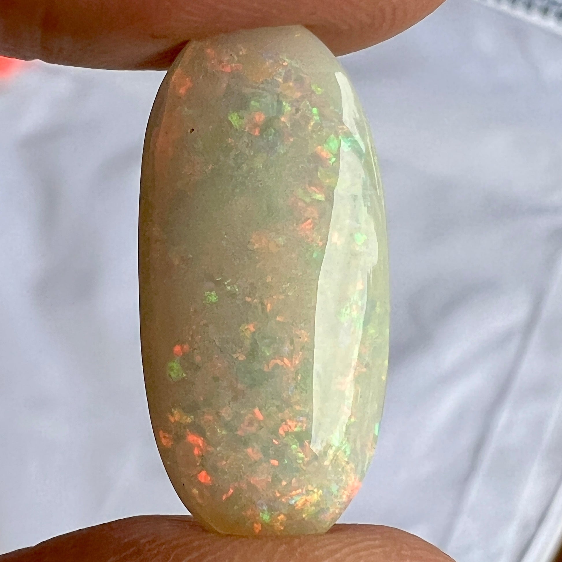 Large solid white double sided opal from Coober Pedy. A gem of a stone, showing all the colours and shapes. Perfectly polished and oval in shape.