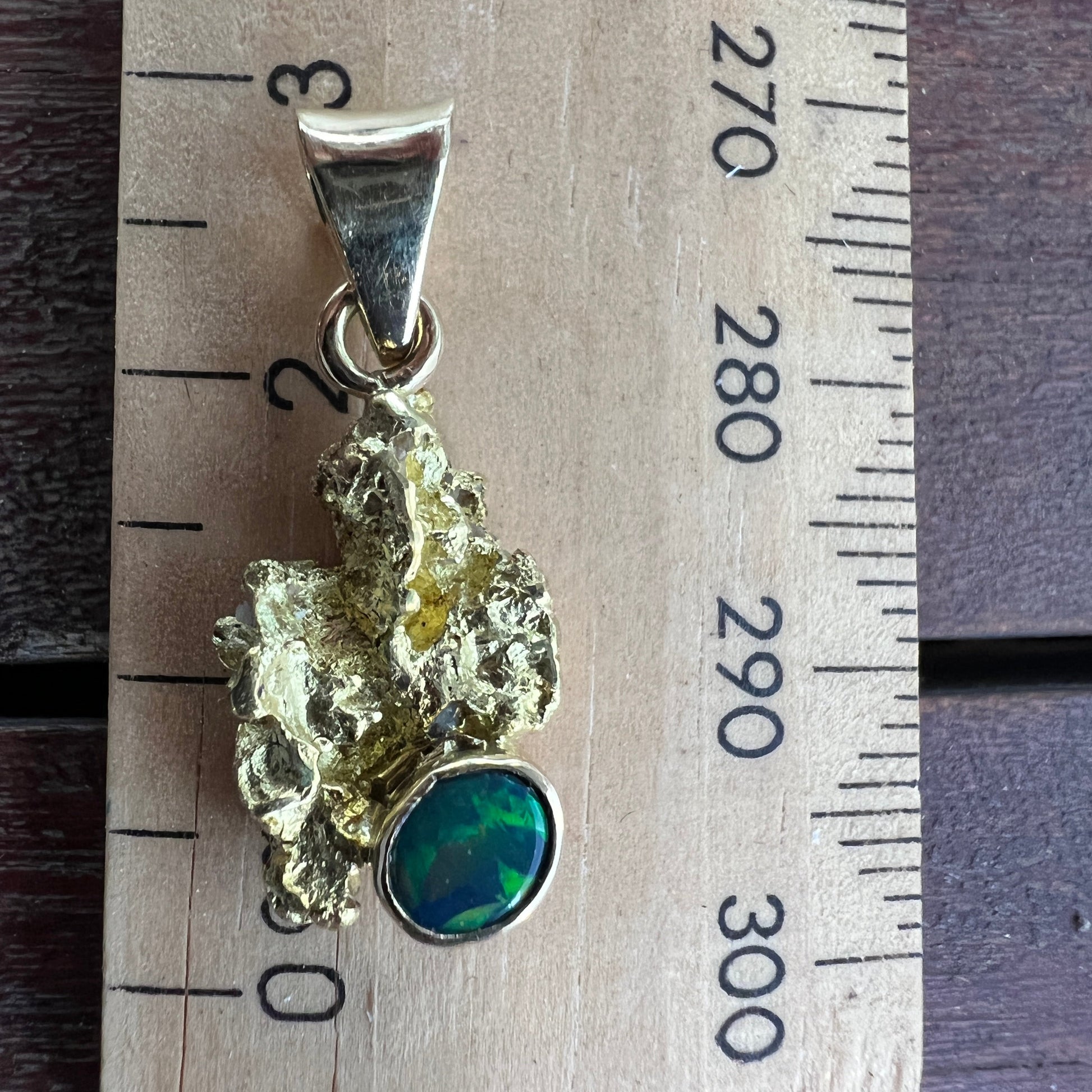 Pure solid gold nugget pendant from Western Australia. Perfectly set with an 18ct bale. Set with a beautifully cut black opal from Lightning Ridge.
