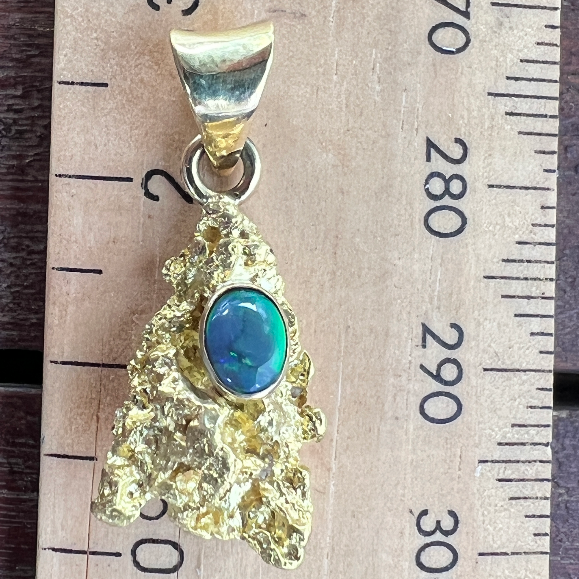 Pure solid gold nugget pendant from Western Australia. Perfectly set and balanced with an 18ct bale. Set with a beautifully cut black opal from Lightning Ridge.