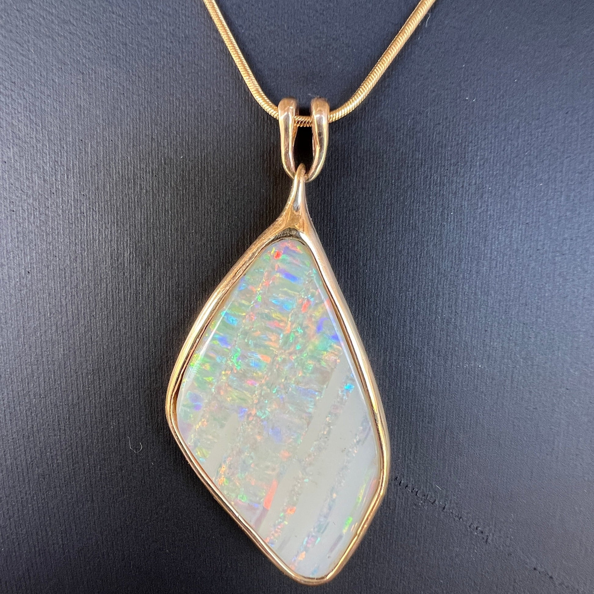 Beautiful solid vertical Mulga from the mine of Craig Haxton in Lightning Ridge. Very simple solid gold setting which enhances the beautiful colours shown in this statement piece. 