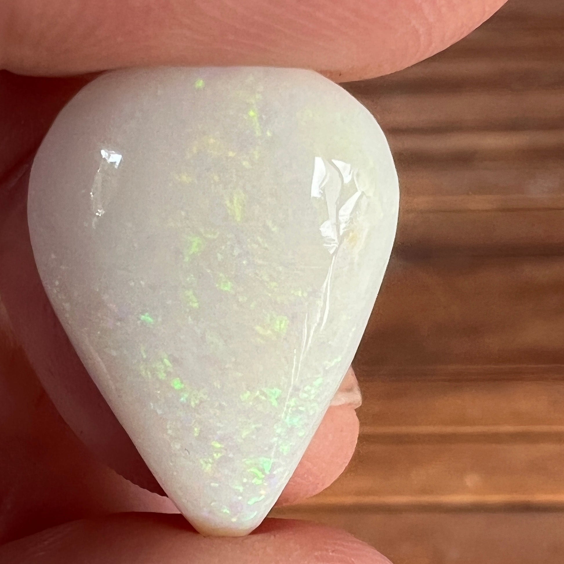 Large teardrop shaped solid white opal from Coober Pedy, featuring striking pinfire greens. Ready for a pendant. An excellent bargain.