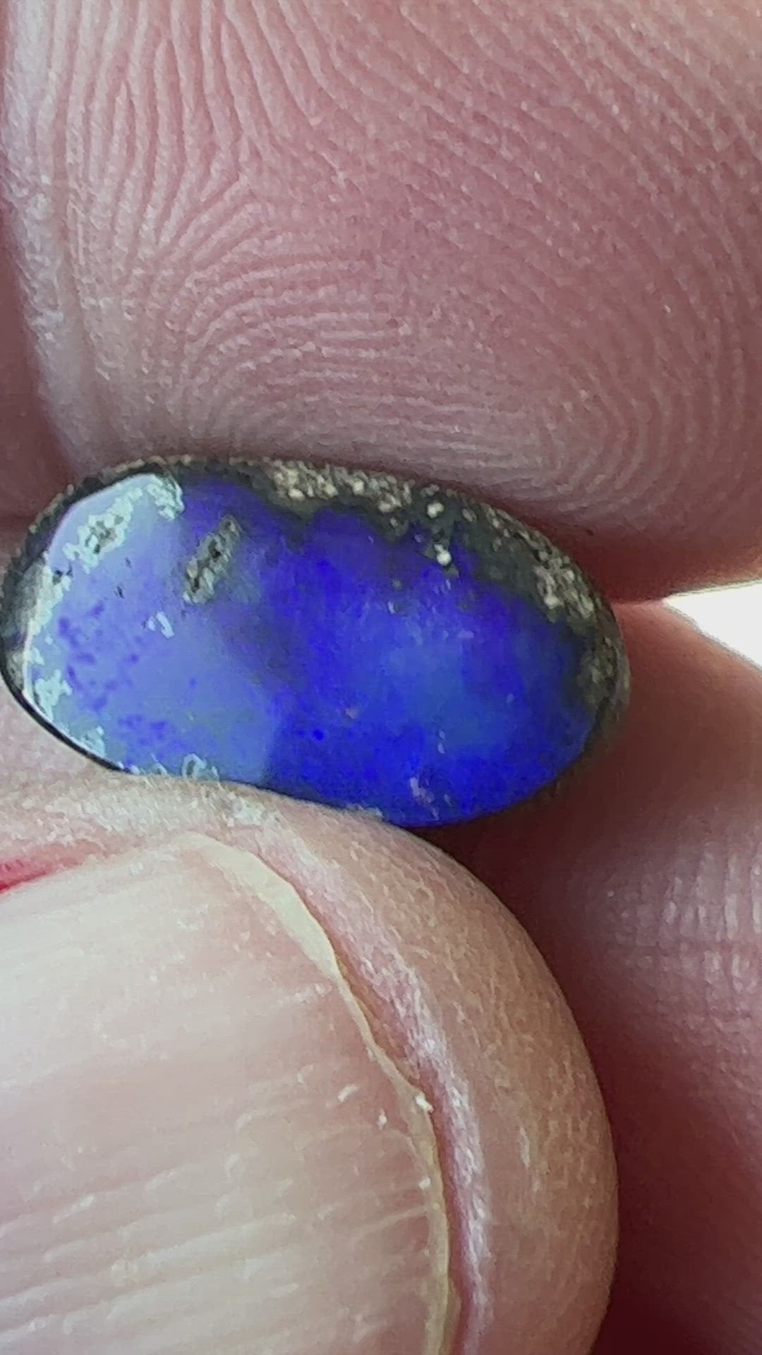 A great shaped little boulder opal with bright blues.