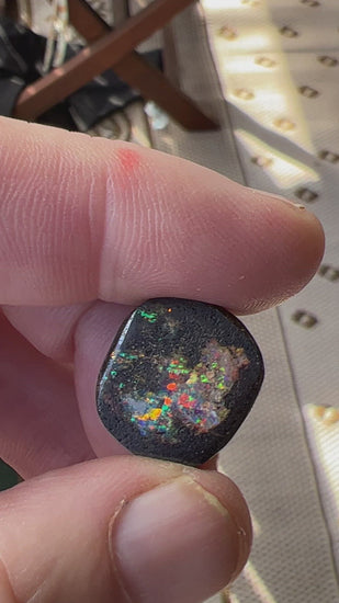 Nice round boulder opal displaying a multitude of colours including reds, blues and greens. 